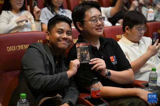 8月24日,在马来西亚吉隆坡,观众在《南京照相馆》马来西亚首映礼上展示电影票。新华社记者 程一恒 摄